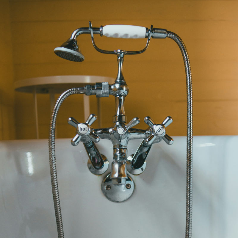obinetterie rétro chromée avec douchette pour l'eau chaude sanitaire sur une baignoire